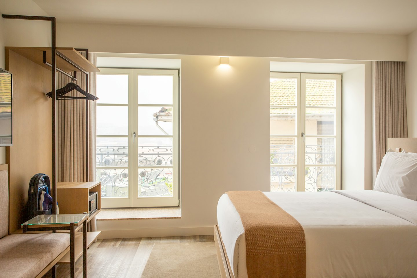 Pokój hotelowy z pościelonym łóżkiem i widokiem na miasto.